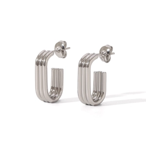 Detailed macro view of silver steel U-shaped earrings with fine linear textures and ribbing