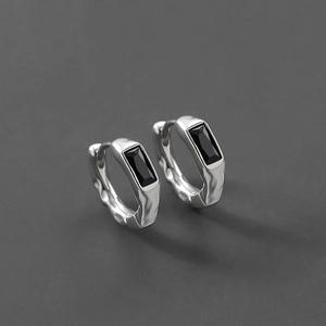 Detailed view of silver hoop earrings featuring rectangular black stone inlays and hammered texture