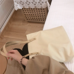 Close-up of durable canvas tote with reinforced leather handles and vintage metal rivets
