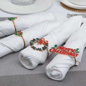 Detail showing assorted gold-plated Christmas napkin rings with enamel holiday patterns