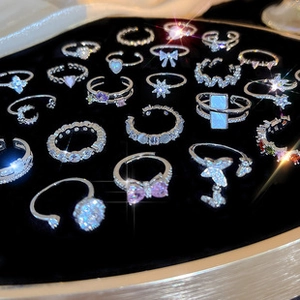 Selection of silver plated rings with colorful crystals on black velvet display