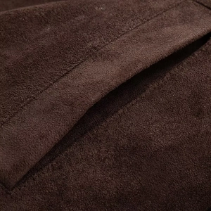 Macro shot of stitching detail on the pocket of a dark brown suede leather jacket