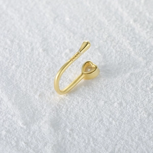 Macro view of gold S925 sterling silver U-shaped nose cuff with heart-shaped zircon stone