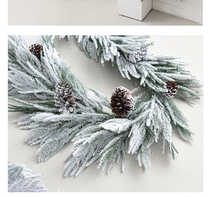 Close-up of artificial pine needles with heavy faux snow and natural pine cones