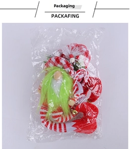 Detail of Christmas gnome plush in transparent packaging with red checkered hat and green beard