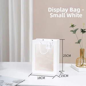 Close-up of white gift bag with transparent PVC window and white handles measuring 18x15x25cm