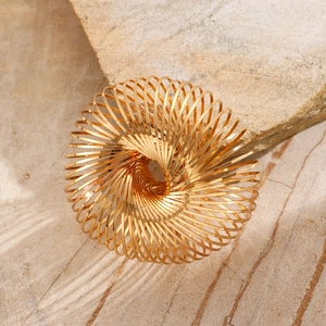 Close-up of golden spiral spring bracelet showing glossy metallic texture and texture detail