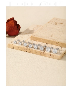 Detailed comparison of S925 sterling silver zircon stud earrings in various sizes on stone