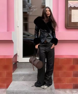 Détail d'un manteau en cuir noir avec col en fourrure et bordure en fausse fourrure