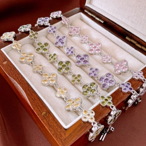 Macro shot of silver clover bracelets with colorful zircon stones in a wooden box