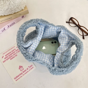 Detailed view of light blue plush handbag interior showing storage capacity for a smartphone