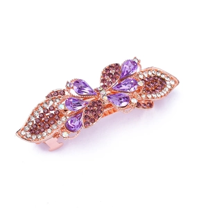Detail of rose gold hairpin with purple and clear rhinestones in leaf-like design