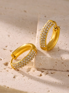 Detailed close-up of gold hoop earrings with pavé set white cubic zirconia stones