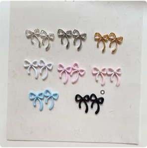 Detail view of 8x11mm bow nail charms in various metallic and pastel colors
