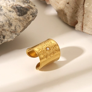 Detail of gold irregular ring with radiant starburst pattern and central zircon stone