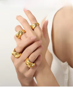 Macro shot of gold plated croissant dome rings with high-polished twisted texture