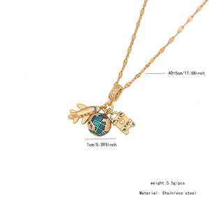 Detail view of gold stainless steel necklace with plane, globe, and suitcase charms