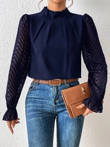 Detail of navy mock neck top with sheer striped chiffon sleeves and pleated collar details
