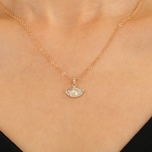 Nahaufnahme einer goldenen fächerförmigen Kette mit Zirkonia, getragen von einem Model