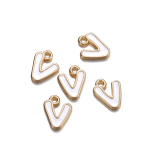Close-up of five white enamel gold-plated V-shaped letter charms for DIY jewelry making