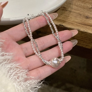 Close-up of a double-layer pearl bracelet with silver faceted beads and a lobster clasp