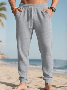 Close-up of light grey waffle texture fabric on men's drawstring jogger pants