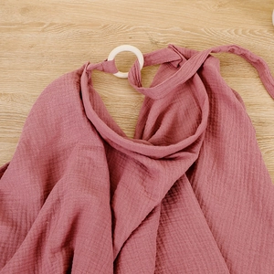 Dettaglio della mantella allattamento in mussola rosa cipria con anello in plastica bianca