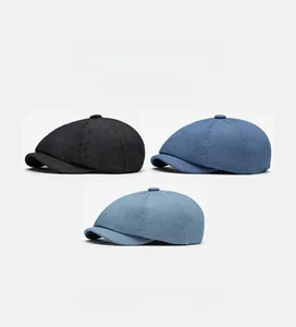 Flat lay of denim newsboy caps in black, navy and light blue with a soft top structure