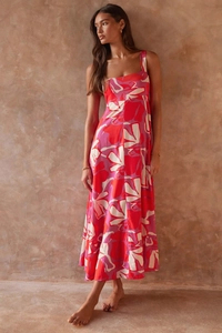Detail of floral print maxi dress with square neckline against a textured clay wall