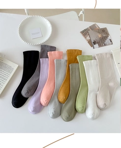 Flat lay of colorful cotton socks in ten solid colors displayed on a white background