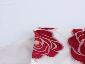 Detailansicht der eleganten Puffärmel aus Netzstoff mit roter Rosen-Stickerei