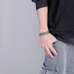 Silver stainless steel curb chain bracelet with snakeskin texture on a male model's wrist