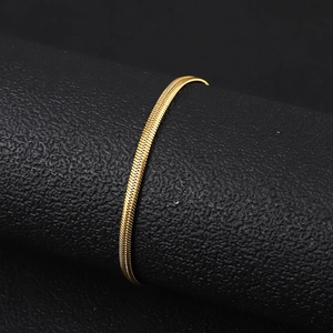 Detail of a polished 18K gold plated stainless steel snake chain on black leather