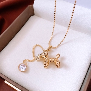 Detailed view of a 14K gold-plated balloon dog pendant with a sparkling zircon on a bead chain