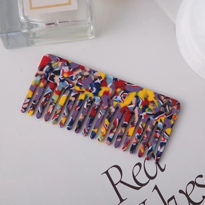 Close-up of a wide-tooth acetate comb featuring a colorful tortoiseshell pattern