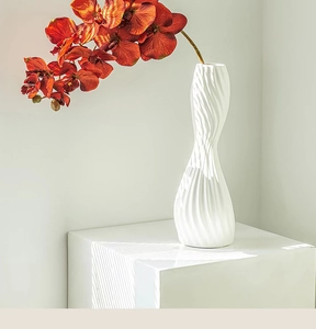 Detailed view of white ceramic vase with elegant spiral texture and artistic soft shadows