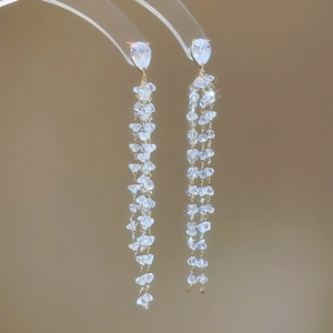 Detailed close-up of 18k gold plated tassel earrings with sparkling zircon drop stones