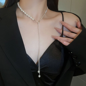 Elegant Y-shaped pearl and silver tassel necklace worn with a black business suit