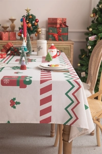 Close-up of festive Christmas tablecloth with red gift boxes and green trees patterns