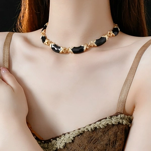 Close-up of vintage gold and black enamel geometric necklace worn on model neck