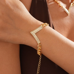 Detailed view of a gold-plated V-shaped bracelet with rhinestones and thick curb chain