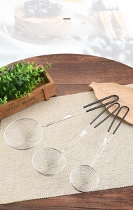 Three-piece set of stainless steel wire skimmers with black non-slip handles on a placemat