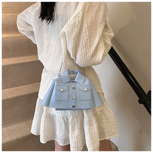 Detail of light blue jacket-shaped crossbody bag with metal chain and decorative buttons