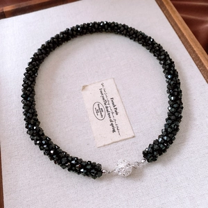 Macro detail of multifaceted black glass beads with silver magnetic crystal clasp
