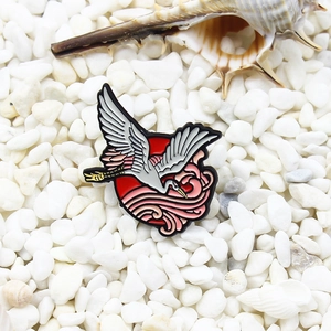 Oriental crane enamel pin with red sun and wave design on a white pebble background