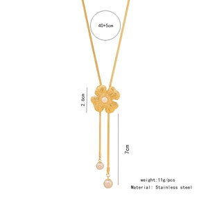 Detailed view of flower pendant with pearls and tassels on golden stainless steel necklace