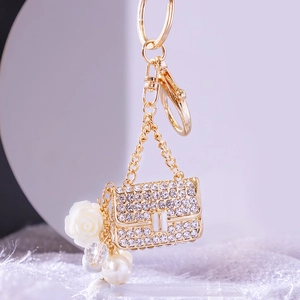 Exquisite pearl handbag keychain with rhinestones and white rose in golden finish