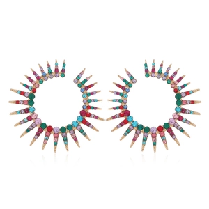 Detailed close-up of radiant gold earrings with colorful rhinestones in a sunburst design