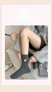 Gros plan de chaussettes en tricot gris avec broderie mouton blanc sur le côté