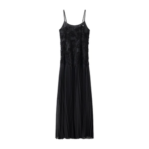 Detail of 3D floral lace applique and pleated skirt on a black maxi slip dress